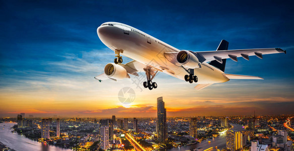 商业飞机以美丽的日落背景占领城市景色图片