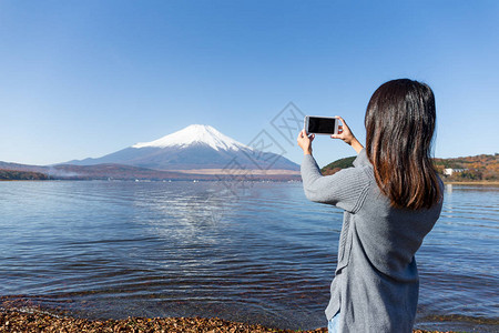 女人用手机拍富士山图片