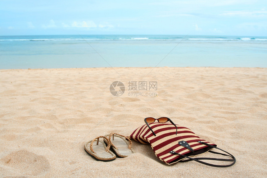 热带沙滩上的一双凉鞋和太阳镜图片