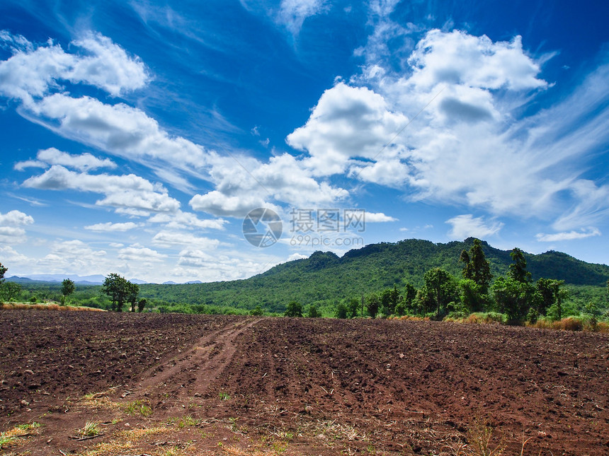 一片田地的棕色农业土壤有蓝天的图片
