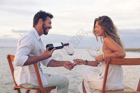 在海边喝红酒的男女情侣图片