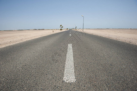 长的直沙漠路在偏远干旱地貌的荒漠地带走图片