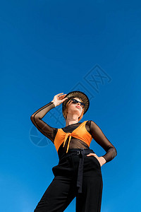 女孩的底部视线出现在潮光太阳镜和时尚帽子中图片