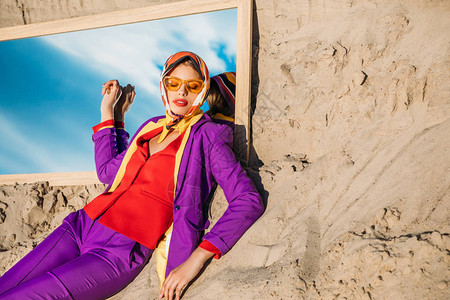 穿着时装的时尚装的女人躺在沙地和镜子上图片