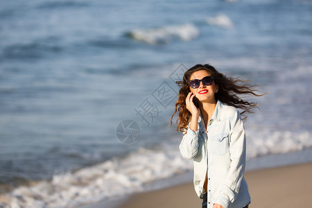 在沙滩上打电话的女人图片