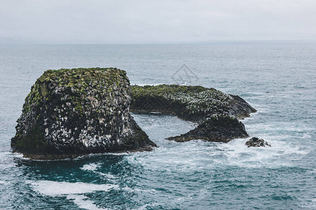 冰岛阿尔纳斯塔皮岛蓝海中岩石的戏剧拍摄图片