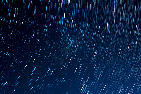 星宿的轨迹与黑夜的空背景图片