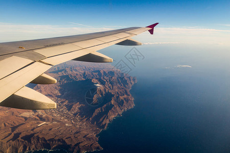 岩石陆地蓝海和飞机翼的背景图片