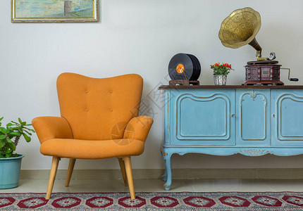 复古橙色扶手椅的复古内饰复古木制浅蓝色餐具柜旧留声机图片
