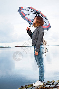 有伞的女孩站在码头上图片