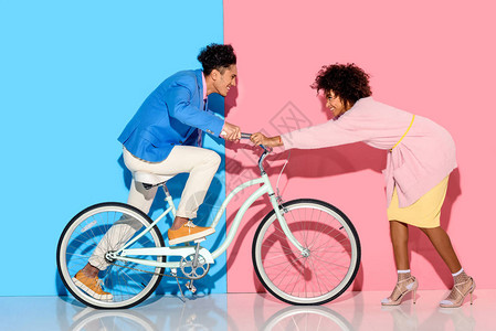 快乐的一对夫妇玩得开心骑着粉色和蓝色图片