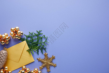 闪亮的金色圣诞装饰绿色Thuja树枝和信封之顶图片