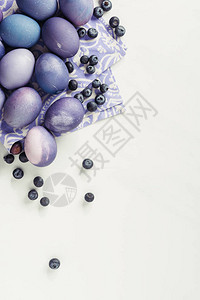 灰色东方概念纸巾上的紫绿漆鸡蛋和蓝背景图片