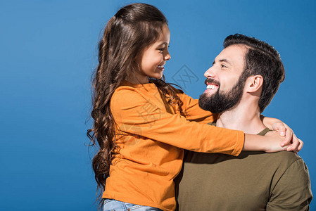 英俊的父亲抱着女儿他们用蓝色的图片