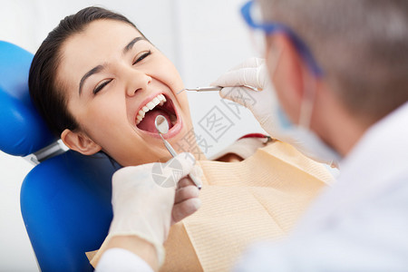 在牙医诊所口腔检查时对张开嘴的女孩图片