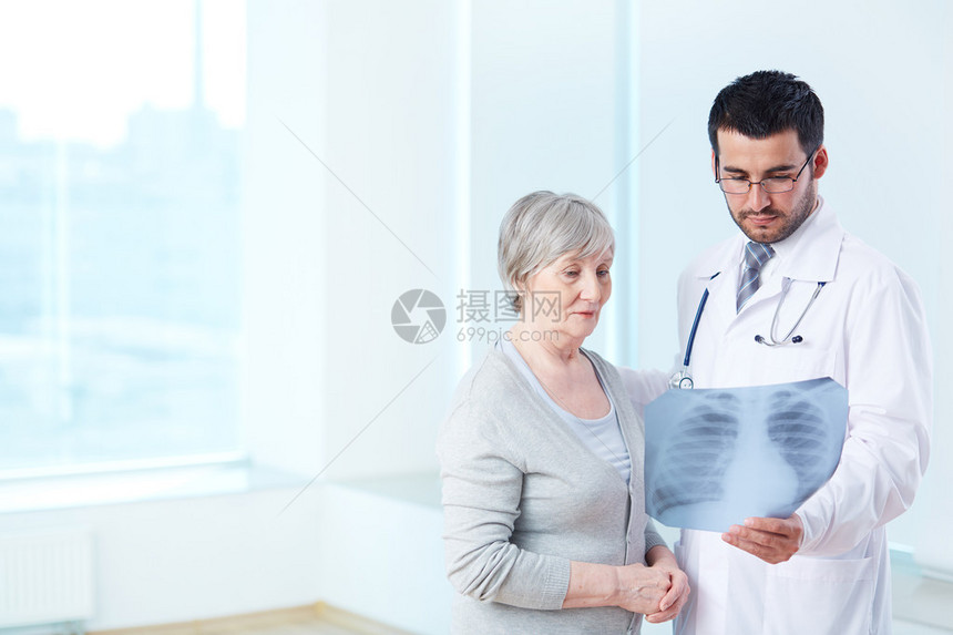 高级病人仔细看病中放射科医生在图片