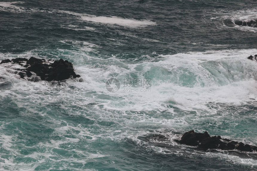 蓝色海洋波浪撞击岩石图片