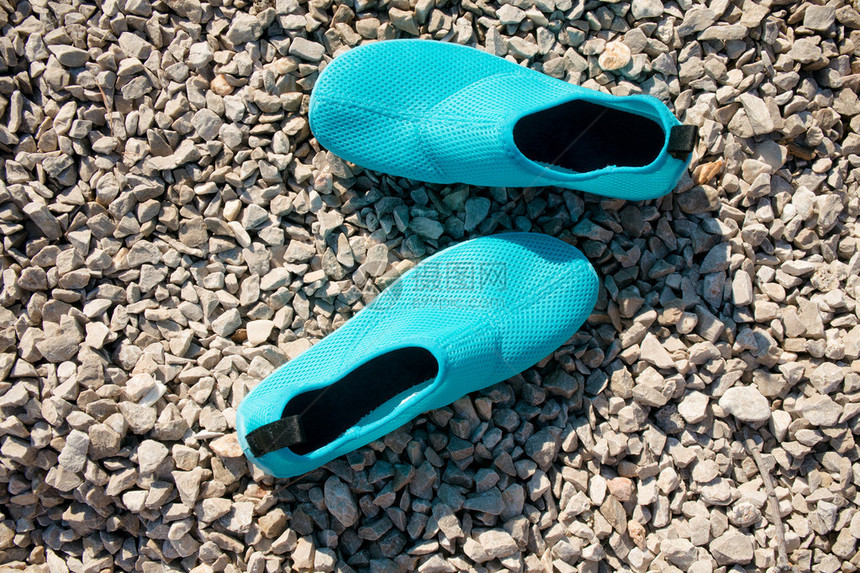 卵石滩上的蓝色水鞋图片