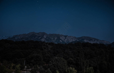 美丽的夜景与星夜山和森林有绿色草甸和山的夜森林在明亮的星夜图片