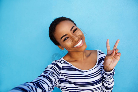 冷酷的年轻黑人女子用和平手牌背景图片