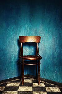 木制椅子在土屋的角落有蓝色背景图片