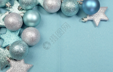 淡蓝色材质桌布背景上的淡蓝色圣诞亮片和星的节日背景背景图片