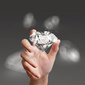 手拿着3d钻石在灰色的背景图片