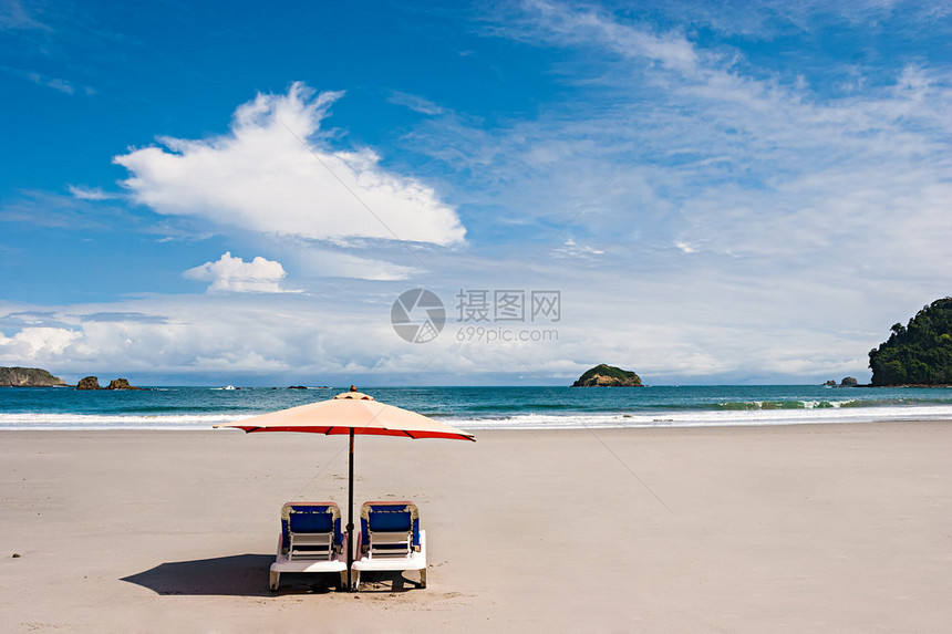 海滩上有两把椅子和伞曼努埃尔安东尼奥图片