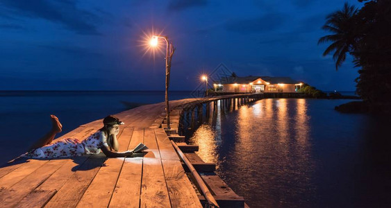 印度尼西亚马鲁古哈塔岛木工场Hatta岛黄昏时用前额光看书图片