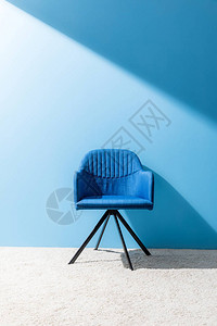 蓝色墙壁前舒适的蓝色椅子图片