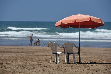在摩洛哥卡萨布兰卡海滩的伞状和两张椅子上图片