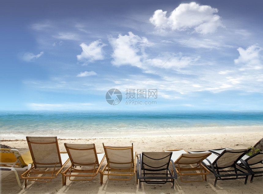 热带海滩在海洋上摆有甲板椅蓝天空图片
