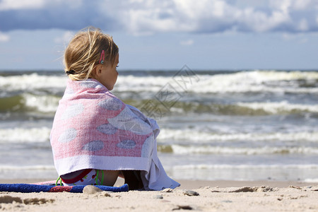 小女孩坐在沙滩上看图片