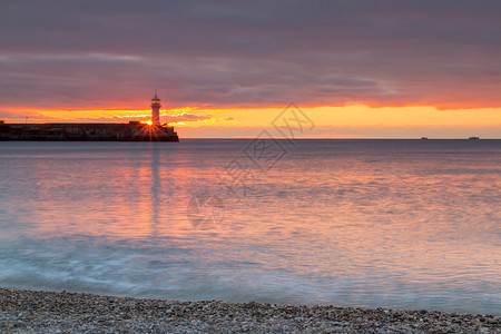 日出时有灯塔的美妙海景图片