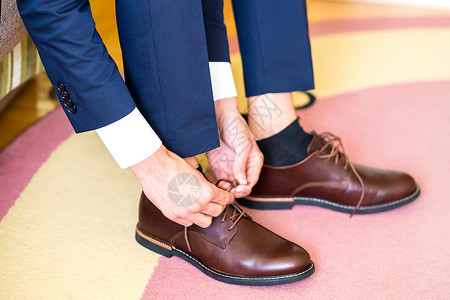 男人穿鞋将鞋带系在鞋子上男士风格专业准备图片