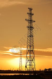 反对日落天空的电力线塔图片