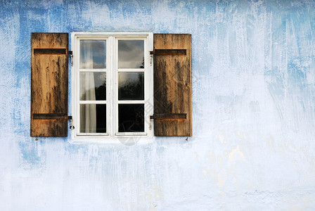 蓝色墙上的旧窗户图片