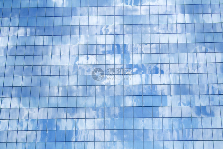 玻璃建筑细节反映蓝色天空中飘忽的云层图片