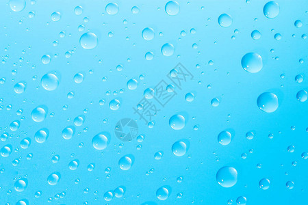 蓝色玻璃背景上的水滴图片