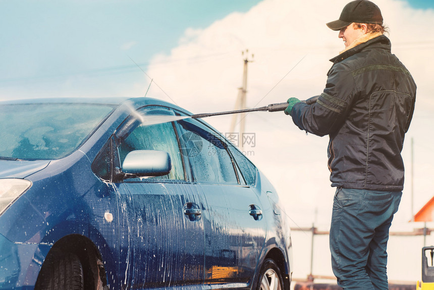 男人用压缩水在汽车图片
