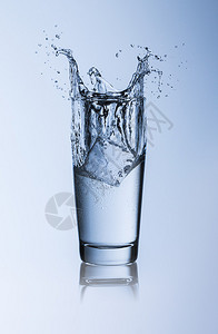 水玻璃飞溅威利杯冰块冷饮用水解渴饮食健康自来水矿泉水瓶装水蓝色背景背景图片