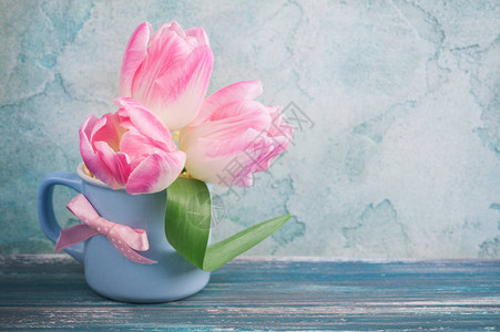粉红色的郁金香花在蓝色杯子图片