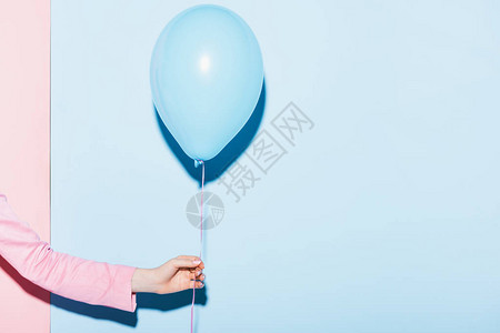 以粉色和蓝色背景持有气球的妇图片
