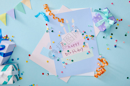 礼品盒和蓝背景的生日贺卡上方彩色面板图案视图背景图片