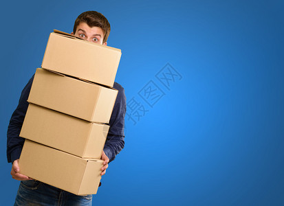 蓝色背景中拿着纸板箱的男人图片
