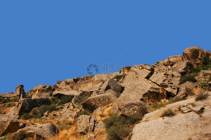 横跨晴朗的天空的岩石图片