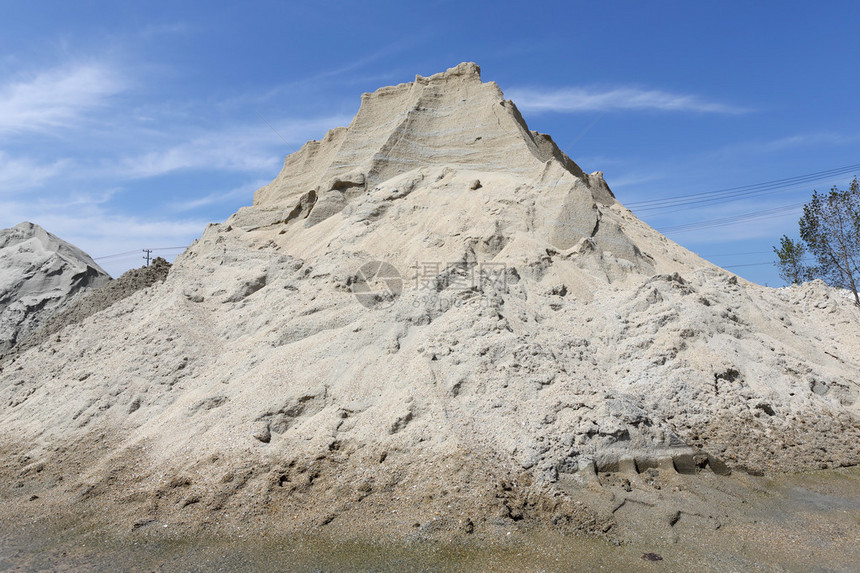 沙子和砾石堆反对蓝天图片