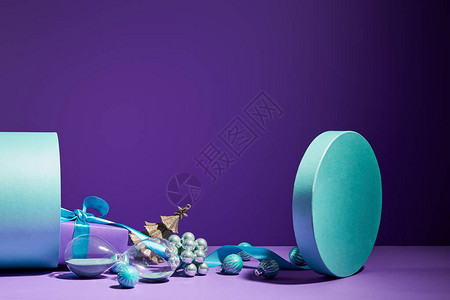 圣诞装饰和沙玻璃从紫色背景的蓝色图片