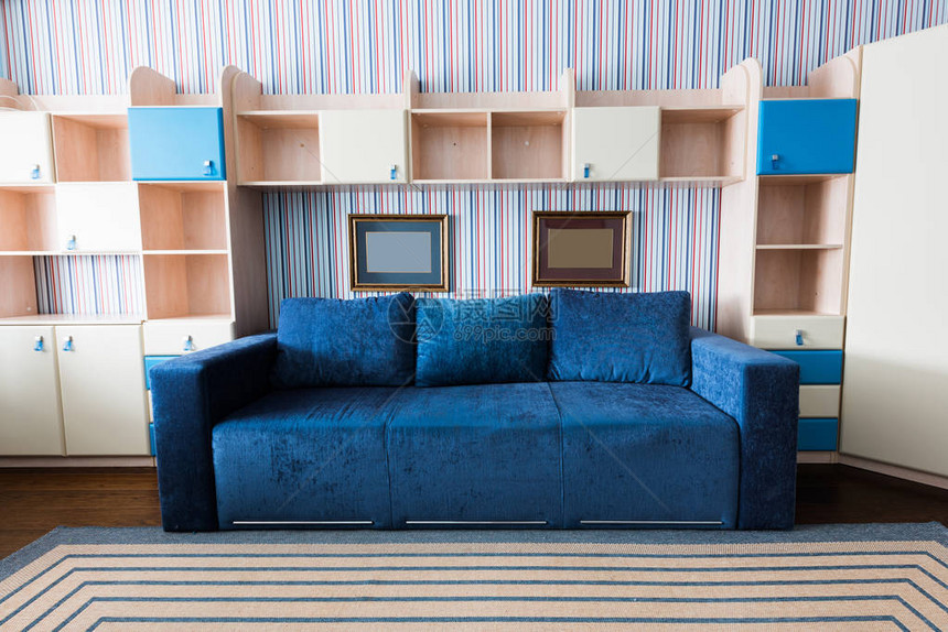 客厅蓝色沙发和木制壁橱的近景图片