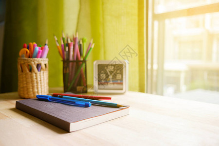 书笔和铅笔放在靠近窗户的桌子上图片